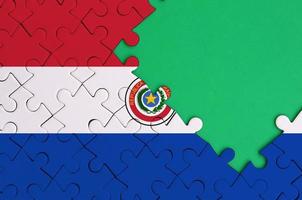 Paraguay flag is depicted on a completed jigsaw puzzle with free green copy space on the right side photo