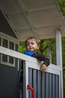 A child is playing on the playground in a children's house. Presents himself as the owner of the house. Portrait of a child photo