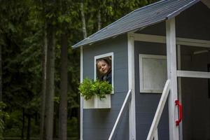 A child is playing on the playground in a children's house. Presents himself as the owner of the house. Portrait of a child photo