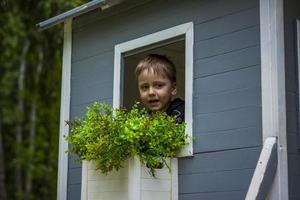 un niño está jugando en el patio de una casa de niños. se presenta como el dueño de la casa. retrato de un niño foto