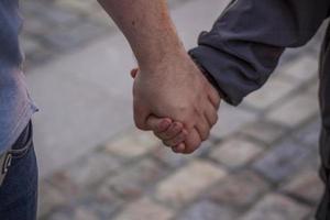 A father holds his son's hand while walking down a city street.  Travel. Lifestyle in the city. Center, streets. photo