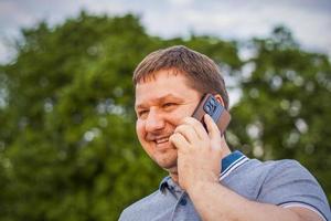 A man with joyful emotions on his face is talking on a mobile phone. Travel. Lifestyle in the city. Center, streets. photo