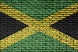 Jamaica flag is painted onto an old brick wall photo