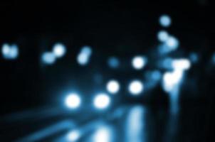 Blurred night scene of traffic on the roadway. Defocused image of cars traveling with luminous headlights. Bokeh Art photo