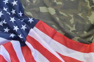 bandera de los estados unidos de américa y chaqueta de uniforme militar doblada. banner de fondo conceptual de símbolos militares para fiestas patrióticas americanas foto