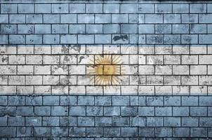 La bandera argentina está pintada en una vieja pared de ladrillos. foto