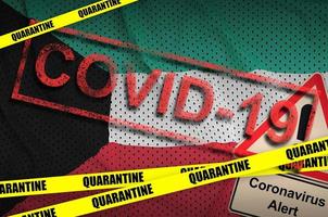 Kuwait flag and Covid-19 quarantine yellow tape with red stamp. Coronavirus or 2019-nCov virus photo