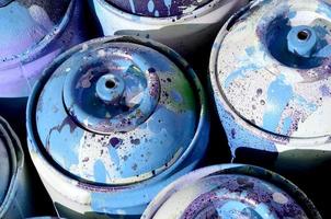 muchos tanques de metal azul usados con pintura para dibujar graffiti foto