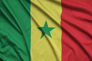 Senegal flag is depicted on a sports cloth fabric with many folds. Sport team banner photo