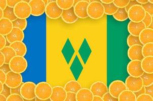 Saint Vincent and the Grenadines flag in fresh citrus fruit slices frame photo