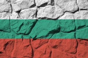 bandera de bulgaria representada en colores de pintura en el primer plano de la pared de piedra antigua. banner texturizado sobre fondo de pared de roca foto