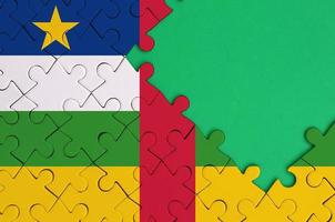 Central African Republic flag is depicted on a completed jigsaw puzzle with free green copy space on the right side photo