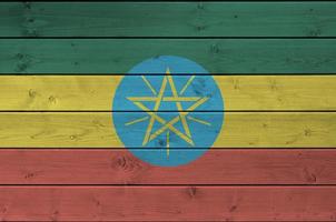 Ethiopia flag depicted in bright paint colors on old wooden wall. Textured banner on rough background photo