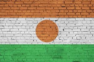 Niger flag is painted onto an old brick wall photo