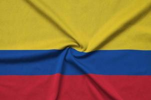 Colombia flag is depicted on a sports cloth fabric with many folds. Sport team banner photo