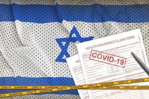 Israel flag and Health insurance claim form with covid-19 stamp. Coronavirus or 2019-nCov virus concept photo