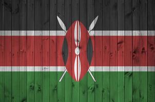 Kenya flag depicted in bright paint colors on old wooden wall. Textured banner on rough background photo