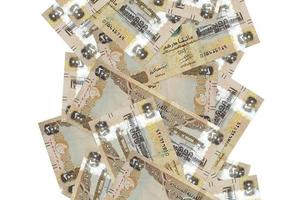 200 UAE dirhams bills flying down isolated on white. Many banknotes falling with white copyspace on left and right side photo