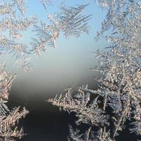 Snowflakes frost rime macro on window glass pane photo