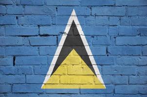 Saint Lucia flag is painted onto an old brick wall photo