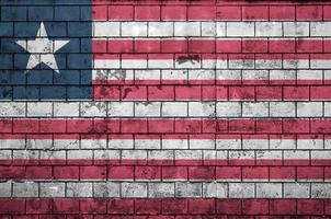 la bandera de liberia está pintada en una vieja pared de ladrillos foto