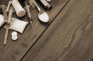 A lot of narcotic substances and devices for the preparation of drugs lie on an old wooden table photo