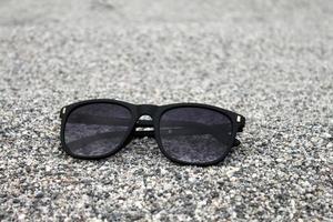 Sunglasses on Sand background Closeup photo