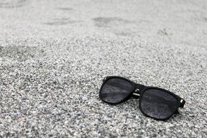 Sunglasses on Sand background Closeup photo