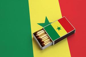 Senegal flag is shown in an open matchbox, which is filled with matches and lies on a large flag photo