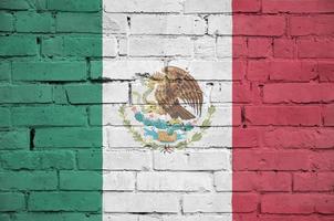 Mexico flag is painted onto an old brick wall photo