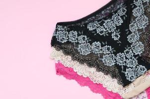 White, black and pink women underwear with lace on pink background with copy space. Advertising for shop of beautiful and comfortable women underwear photo