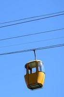 Blue and yellow passenger cable way cabins in the clear sky photo