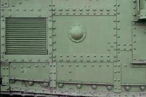 Texture of tank side wall, made of metal and reinforced with a multitude of bolts and rivets photo