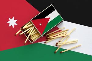 Jordan flag is shown on an open matchbox, from which several matches fall and lies on a large flag photo