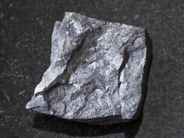 raw carbonaceous shale stone on dark photo