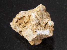 raw travertine stone on dark background photo