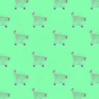 Shopping addiction, shopping lover or shopaholic concept. Many small empty shopping carts perform a pattern on a pastel colored paper background. Flat lay composition, top view photo