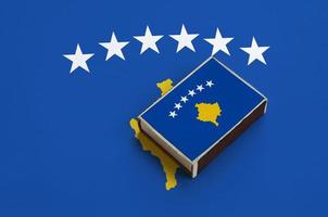 la bandera de kosovo se representa en una caja de fósforos que se encuentra en una bandera grande foto