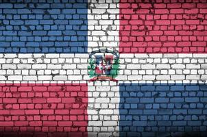 Dominican Republic flag is painted onto an old brick wall photo