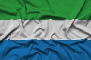 la bandera de sierra leona está representada en una tela deportiva con muchos pliegues. bandera del equipo deportivo foto