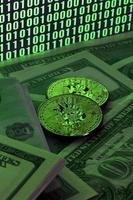 Two bitcoins lies on a pile of dollar bills on the background of a monitor depicting a binary code of bright green zeros and one units on a black background. Low key lighting photo