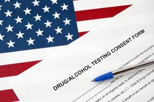 Drug and alcohol testing consent form with blue pen on United States flag photo