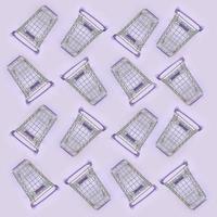 Pattern of many small shopping carts on a violet background. Minimalism flat lay top view photo