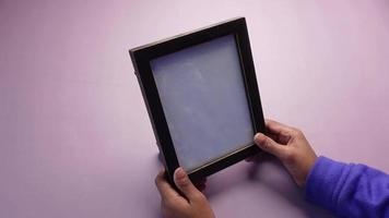 Person holds empty picture frame in hands video