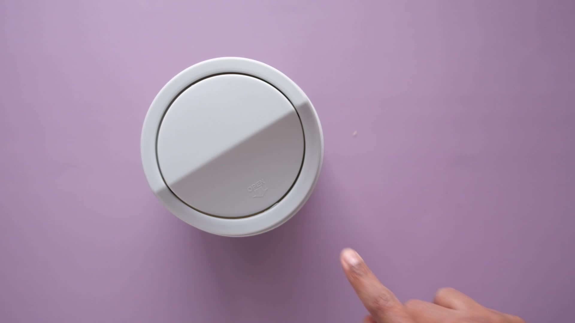 Overhead view of putting wadded paper in a mini desk top trash can