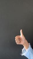 Thumbs up gesture in front of black background wall video