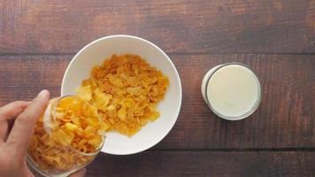 Adding corn cereal to a bowl, top view video