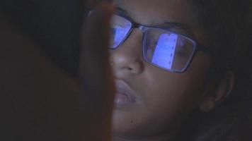 Mann mit Brille, der im Dunkeln auf den Computermonitor blickt video