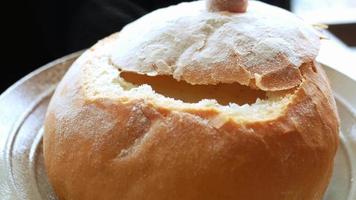 A bread bowl with soup, close up video