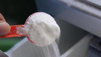 Adding laundry soap to washing machine, close up video